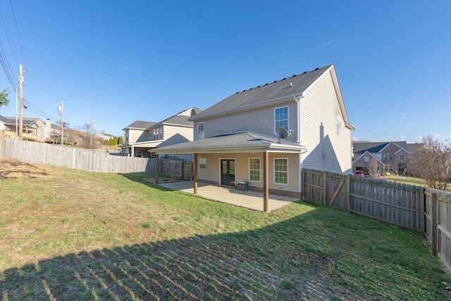 back of property with a yard, a fenced backyard, and a patio area