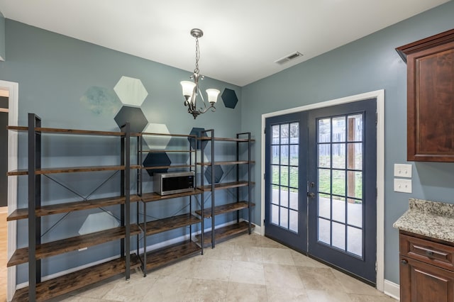 doorway with visible vents, baseboards, a chandelier, and french doors