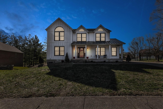 modern farmhouse style home with covered porch, board and batten siding, a front yard, a standing seam roof, and metal roof