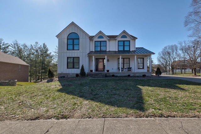 modern farmhouse with board and batten siding, a standing seam roof, a porch, and a front lawn