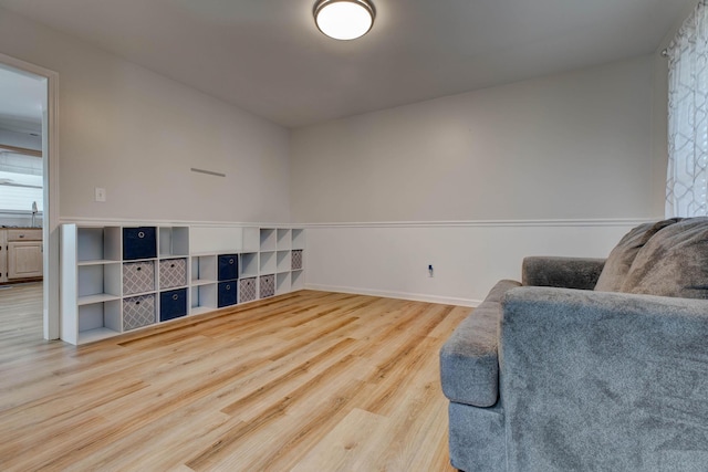 living area featuring baseboards and wood finished floors