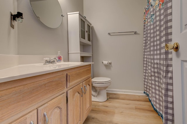 full bath with toilet, wood finished floors, vanity, baseboards, and a shower with curtain