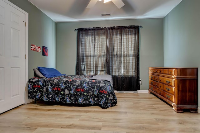 bedroom featuring ceiling fan, wood finished floors, and visible vents