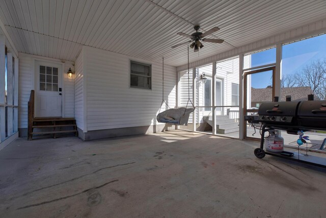 unfurnished sunroom with ceiling fan