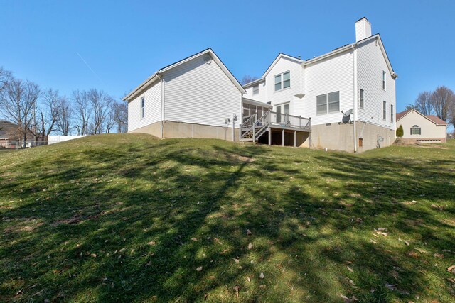 rear view of property with stairway, a lawn, a chimney, and a wooden deck