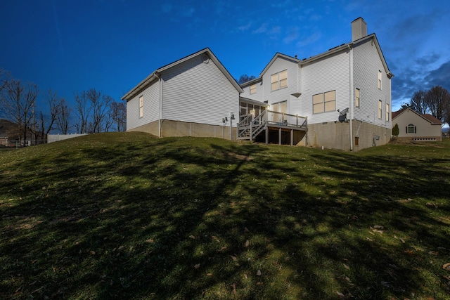 rear view of property featuring stairs, a chimney, a deck, and a yard