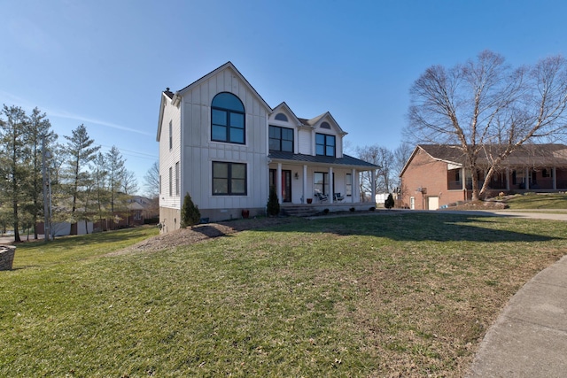 modern farmhouse featuring metal roof, a standing seam roof, covered porch, a front lawn, and board and batten siding