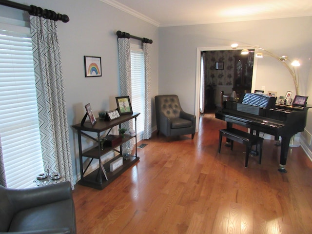 living area featuring ornamental molding, baseboards, and wood finished floors