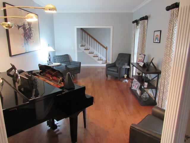 living area featuring stairs, crown molding, and wood finished floors