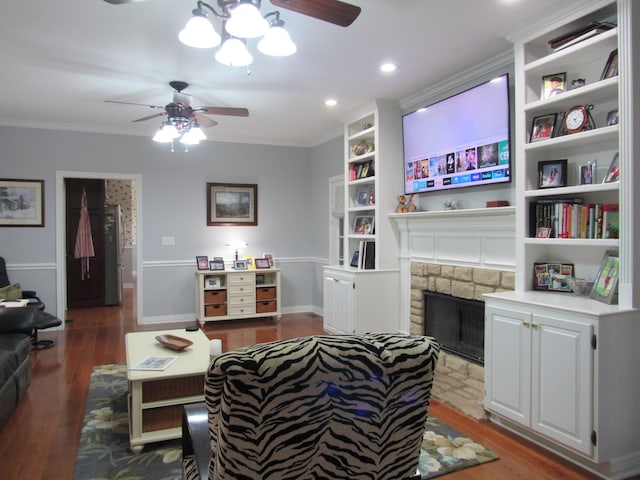 living room with ceiling fan, a fireplace with flush hearth, wood finished floors, and ornamental molding