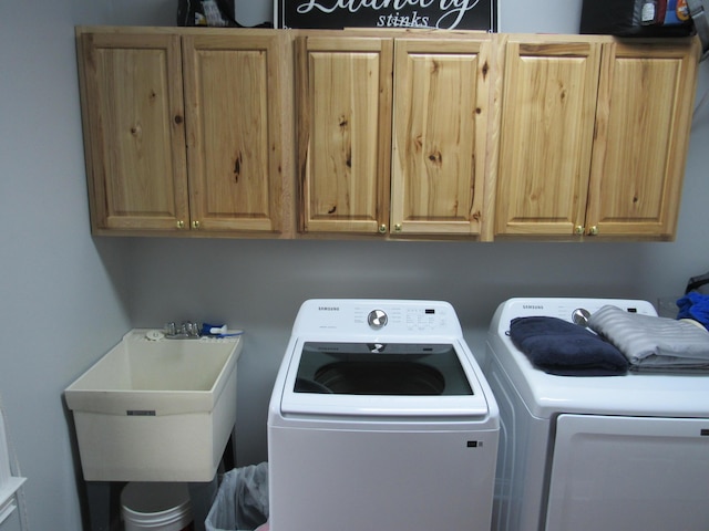 laundry area featuring cabinet space, washer and dryer, and a sink