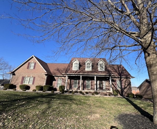 new england style home with brick siding and a front lawn