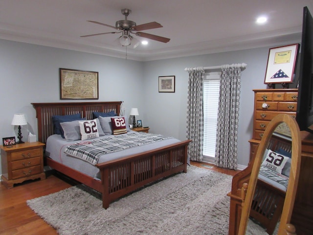 bedroom with ornamental molding, recessed lighting, wood finished floors, and ceiling fan