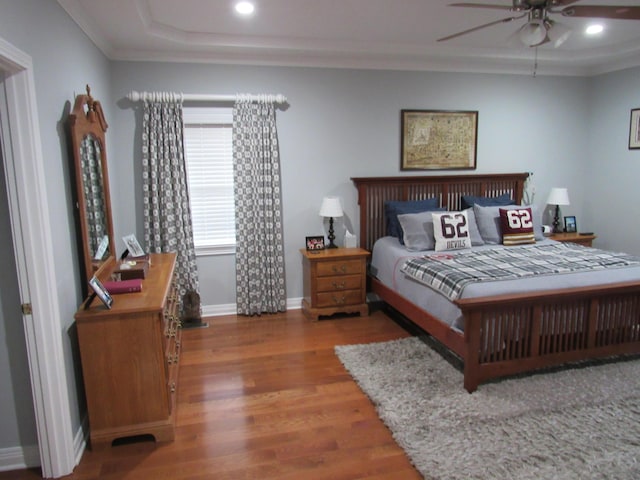 bedroom featuring a ceiling fan, wood finished floors, baseboards, recessed lighting, and ornamental molding