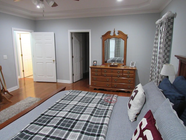 bedroom featuring ornamental molding, baseboards, and wood finished floors