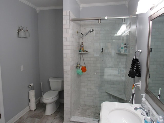 full bathroom with baseboards, toilet, ornamental molding, a stall shower, and a sink