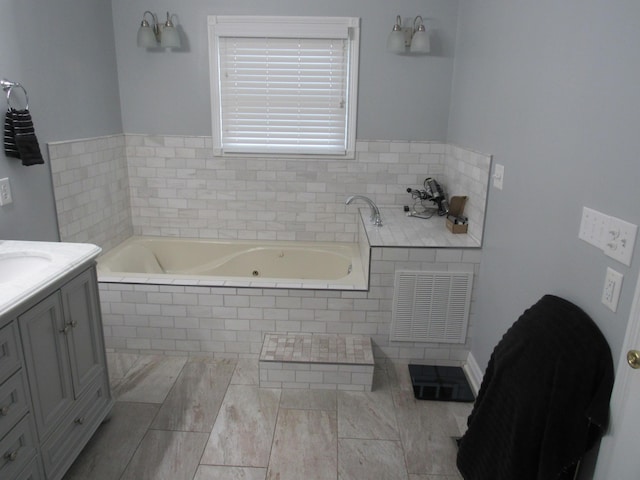 bathroom featuring visible vents, a bath, and vanity