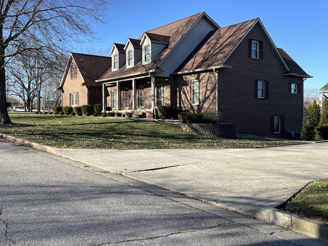 view of front of home featuring brick siding and a lawn