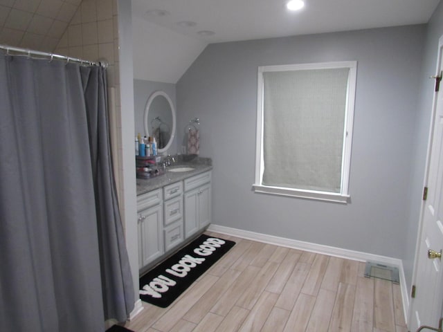 full bathroom with visible vents, baseboards, lofted ceiling, wood finished floors, and vanity