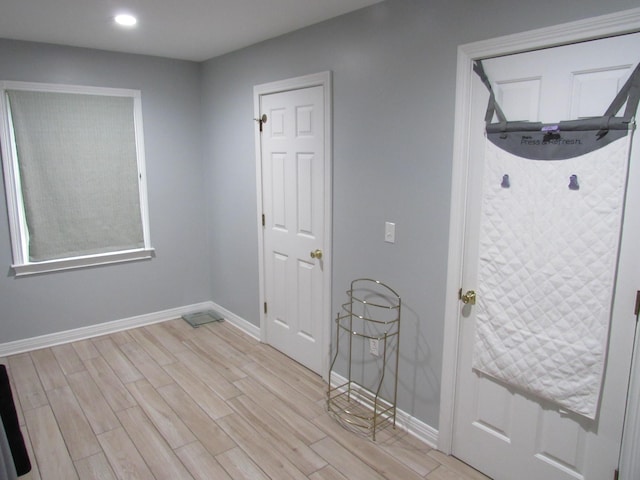 interior space featuring recessed lighting, baseboards, and light wood finished floors