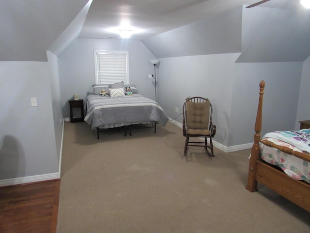 carpeted bedroom with baseboards and vaulted ceiling