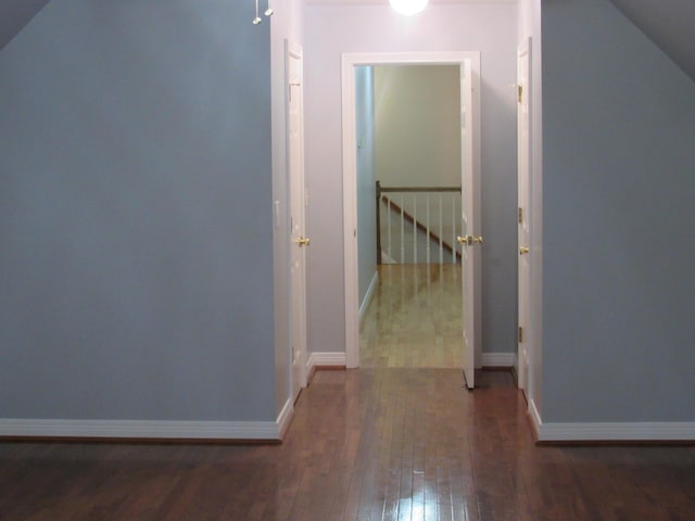 hall featuring hardwood / wood-style flooring and baseboards