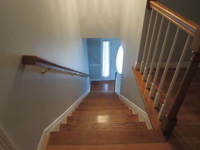 stairway featuring baseboards and wood finished floors