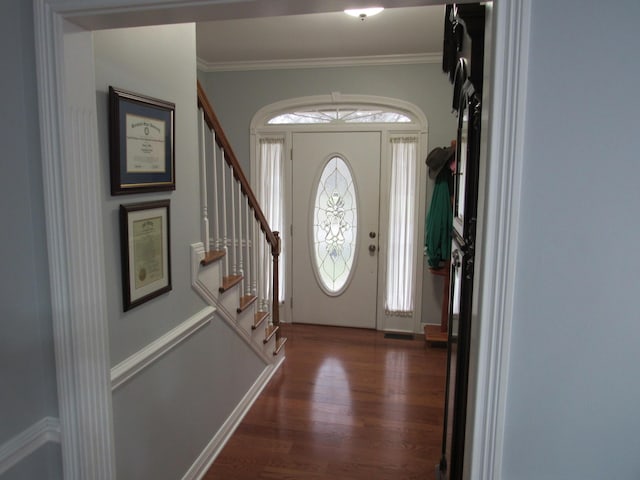 foyer with stairway, wood finished floors, and ornamental molding