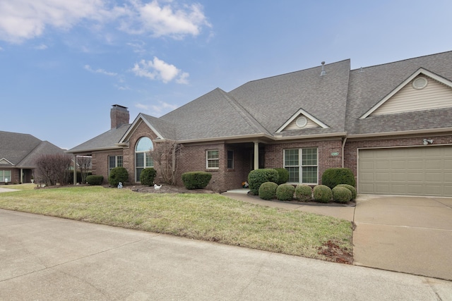 view of front of property featuring a garage, brick siding, a shingled roof, a chimney, and a front yard