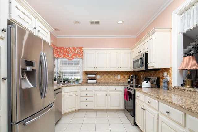 kitchen featuring light tile patterned floors, stainless steel appliances, visible vents, ornamental molding, and decorative backsplash