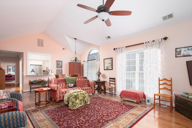 living area with lofted ceiling, wood finished floors, and visible vents