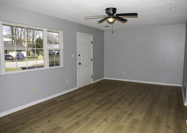 unfurnished room with a ceiling fan, a textured ceiling, baseboards, and wood finished floors