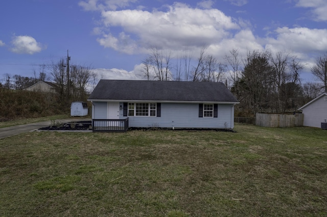 view of front of home with central AC, a front yard, and fence