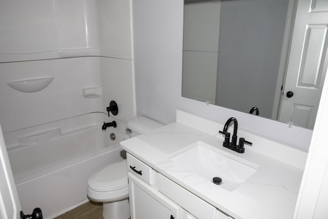 bathroom featuring wood finished floors, vanity, toilet, and bathing tub / shower combination