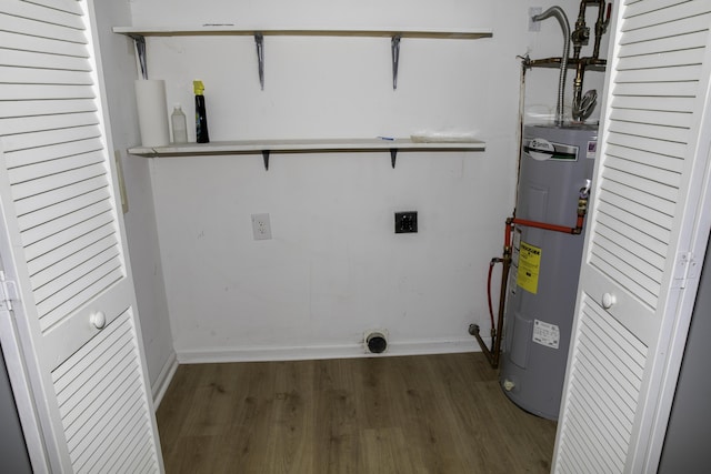 clothes washing area with water heater, electric dryer hookup, baseboards, and wood finished floors