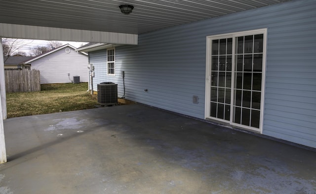 view of patio / terrace with a carport, fence, and central air condition unit