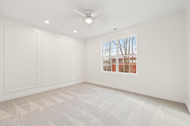 spare room with crown molding, light colored carpet, a decorative wall, and visible vents