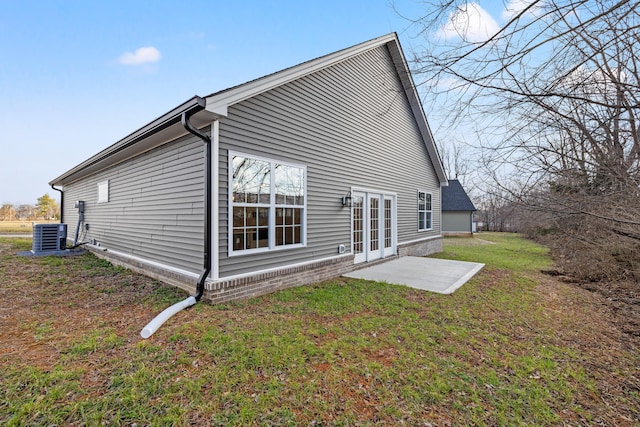 rear view of property featuring a patio area, a yard, and central air condition unit