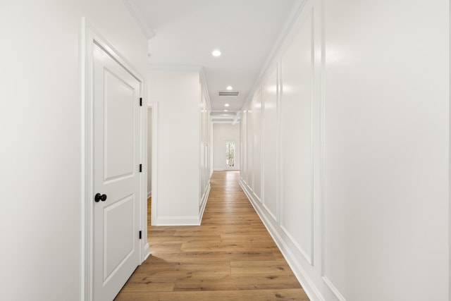 hall with recessed lighting, visible vents, ornamental molding, light wood-type flooring, and baseboards