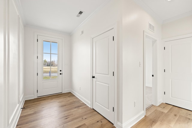 entryway featuring baseboards, light wood-type flooring, visible vents, and crown molding