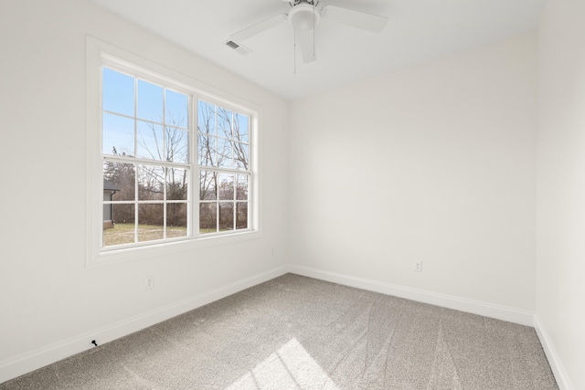 carpeted empty room with visible vents, ceiling fan, and baseboards