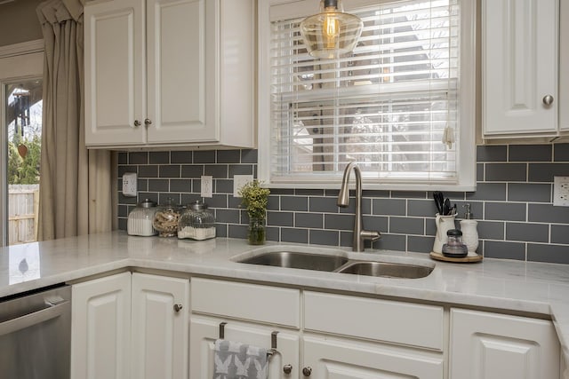 kitchen with a healthy amount of sunlight, white cabinetry, dishwasher, and a sink