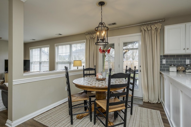 dining area featuring dark wood-style floors, baseboards, and visible vents