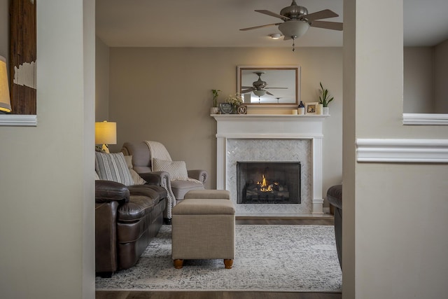 living area with a fireplace and ceiling fan