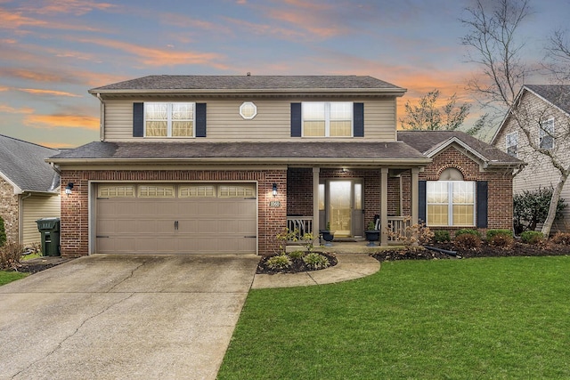 traditional home featuring a porch, an attached garage, brick siding, concrete driveway, and a front lawn