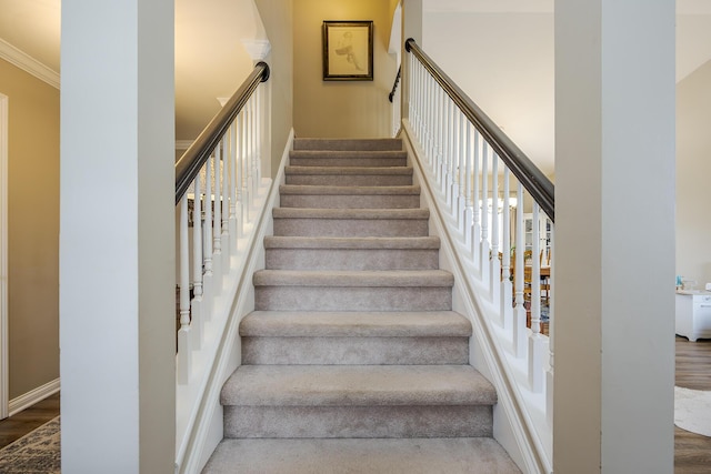 stairs featuring wood finished floors and a towering ceiling