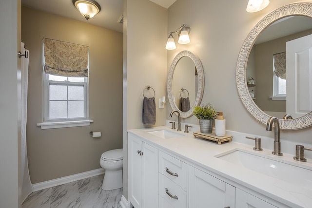 full bathroom featuring toilet, marble finish floor, baseboards, and a sink