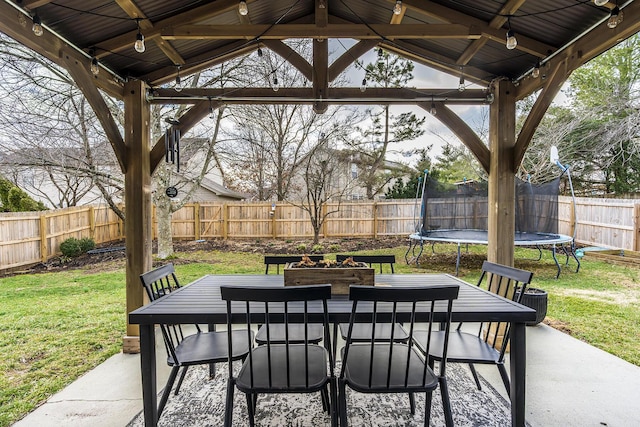 view of patio featuring a gazebo, a trampoline, outdoor dining area, and a fenced backyard