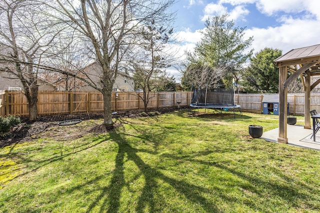 view of yard featuring a patio, a trampoline, a gazebo, and a fenced backyard