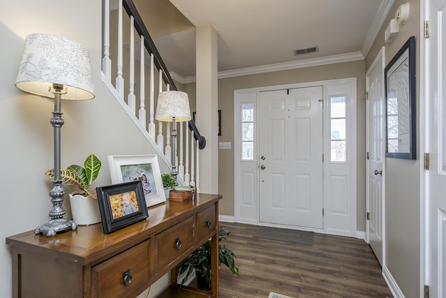 foyer featuring dark wood finished floors, visible vents, stairway, ornamental molding, and baseboards